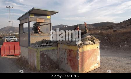 NABLUS, CISGIORDANIA - 19 OTTOBRE: I soldati israeliani stanno in guardia dietro blocchi di cemento nel checkpoint militare di Beit Furik il 19 ottobre 2022 situato all'entrata orientale di Nablus, Cisgiordania. Le forze israeliane hanno imposto un continuo blocco sulla zona intorno a Nablus, tra le tensioni più forti in Cisgiordania che limitano il movimento di circa 420.000 palestinesi. Credit: Eddie Gerald/Alamy Live News Foto Stock