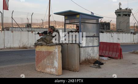 I soldati israeliani puntano la loro arma mentre sono in guardia dietro blocchi di cemento nel checkpoint militare di Beit Furik il 19 ottobre 2022 situato all'entrata orientale di Nablus, in Cisgiordania Israele Foto Stock