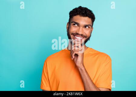 Primo piano foto di attraente positivo uomo indossare abiti alla moda cercare spazio vuoto interessante notizie isolato su sfondo di colore ciano Foto Stock