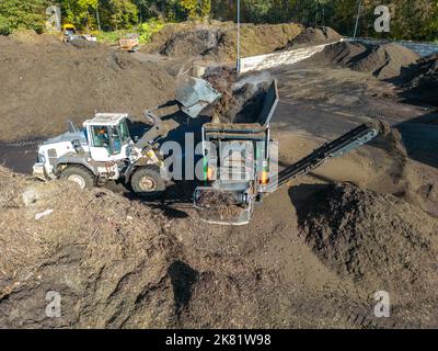 Impianto di compostaggio, biowaste è compostato, ordinato per taglia, parti più piccole sono riutilizzate come compostaggio, parti più grossolane sono bruciate in una pianta di potere di biomassa e co Foto Stock