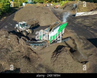 Impianto di compostaggio, biowaste è compostato, ordinato per taglia, parti più piccole sono riutilizzate come compostaggio, parti più grossolane sono bruciate in una pianta di potere di biomassa e co Foto Stock