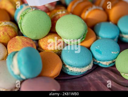 Mucchio di macaron francesi colorati sul piatto Foto Stock