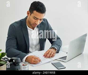 Per quanto riguarda ora Ive un'arma diversa. Un uomo d'affari che fa la documentazione alla sua scrivania in un ufficio moderno. Foto Stock