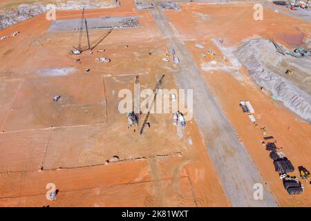 Lavori su fondazioni verticali utilizzando pompe montate su autocarro, lavori di perforazione del terreno sotto le colonne, pompaggio di terreni in sudore di calcestruzzo ad alta pressione Foto Stock