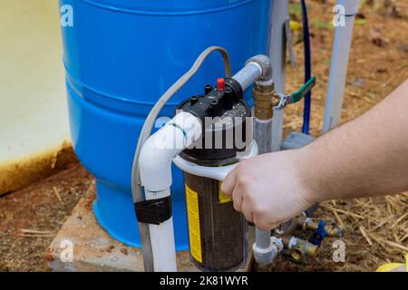 Al fine di mantenere l'acqua pulita all'esterno della casa, i lavoratori professionisti sostituiscono regolarmente i filtri sostituibili Foto Stock