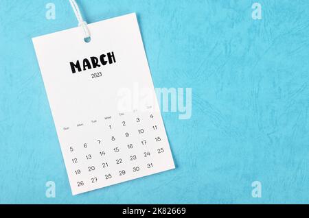 2023 marzo pagina del calendario appeso su corda bianca su sfondo blu. Foto Stock