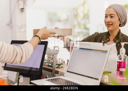 Cameriera che offre al cliente cibo da asporto al ristorante. Foto Stock