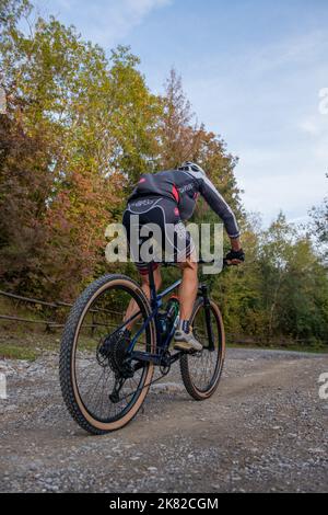 Dossena Italia 13 ottobre 2022: Ciclista che percorre una strada sterrata in montagna Foto Stock