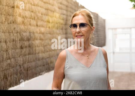 Ritratto di donna anziana matura che indossa occhiali da sole all'aperto. Foto Stock