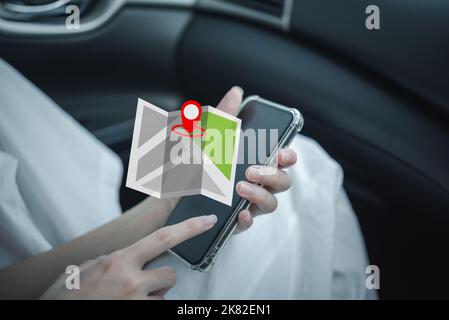 donna che tiene la mano touchscreen smartphone e controllare la mappa di navigazione gps in auto. Foto Stock