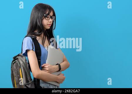 Persona ragazza teen asiatica che tiene computer portatile in background.Education imparando di nuovo a scuola concept.copy spazio. Foto Stock