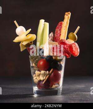 Jarcuterie in un bicchiere, la versione moderna di salumi con vari tipi di salsicce e formaggi Foto Stock