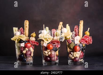 Jarcuterie in un bicchiere, la versione moderna di salumi. Comprende vari tipi di salsicce, sottaceti e formaggi Foto Stock