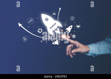 Concetto di avvio. Businessman touch icona di lancio razzo e connessione di rete su ologramma interfaccia virtuale. Successo aziendale rapido. Foto Stock