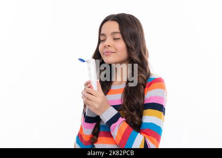 Ragazza adolescente con shampoo balsamo o gel doccia. Cura dei capelli dei bambini. Prodotto cosmetico per capelli, bottiglia di shampoo. Foto Stock