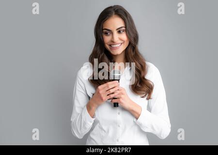 Bella donna d'affari sta parlando in conferenza. Ritratto di giovane giornalista donna in camicia casual con microfono, facendo domande Foto Stock