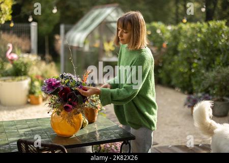 Donna che organizza bei fiori in mazzo all'aperto Foto Stock