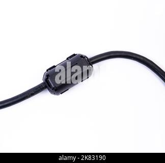 Primo piano di un induttore a cordone di ferrite. Un elemento elettrico che sopprime il rumore elettronico ad alta frequenza nei circuiti elettronici. Su bianco isolato Foto Stock