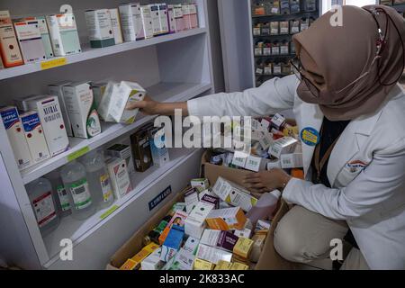 Kendari, Indonesia. 20th Ott 2022. 20 ottobre 2022, Kendari, Sud-est Sulawesi, Indonesia: Un farmacista scarica una linea di farmaci tipo sciroppo da uno scaffale di vendita in una farmacia. Il Ministero della Salute ha dato istruzioni di non somministrare o prescrivere temporaneamente farmaci da banco sotto forma di sciroppo al pubblico a causa di casi atipici di insufficienza renale acuta progressiva si sta verificando nei bambini in Indonesia. (Credit Image: © Andry Denisah/SOPA Images via ZUMA Press Wire) Credit: ZUMA Press, Inc./Alamy Live News Foto Stock