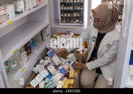 Kendari, Indonesia. 20th Ott 2022. 20 ottobre 2022, Kendari, Sud-est Sulawesi, Indonesia: Un farmacista svuota uno scaffale riempito di sciroppo in una farmacia. Il Ministero della Salute ha dato istruzioni di non somministrare o prescrivere temporaneamente farmaci da banco sotto forma di sciroppo al pubblico a causa di casi atipici di insufficienza renale acuta progressiva si sta verificando nei bambini in Indonesia. (Credit Image: © Andry Denisah/SOPA Images via ZUMA Press Wire) Credit: ZUMA Press, Inc./Alamy Live News Foto Stock