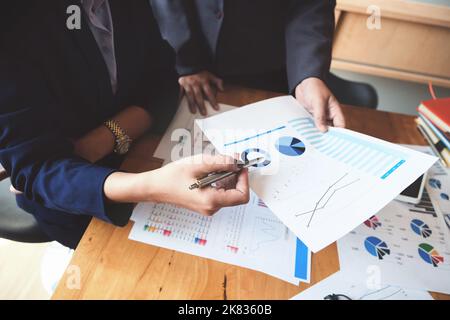 Un revisore ha una penna che indica i documenti per esaminare i bilanci e le frodi finanziarie. Foto Stock