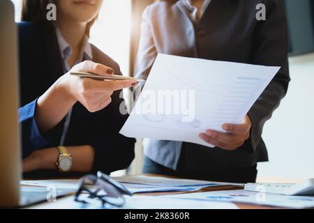 Un revisore ha una penna che indica i documenti per esaminare i bilanci e le frodi finanziarie Foto Stock