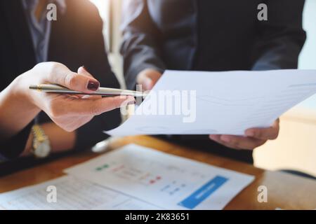 Un revisore ha una penna che indica i documenti per esaminare i bilanci e le frodi finanziarie. Foto Stock