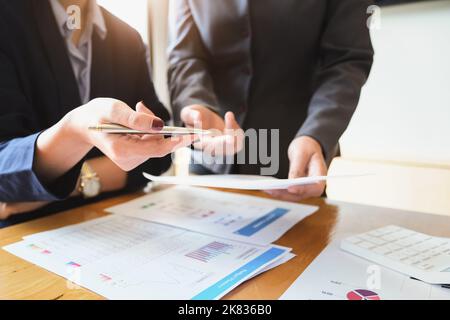 Un revisore ha una penna che indica i documenti per esaminare i bilanci e le frodi finanziarie. Foto Stock