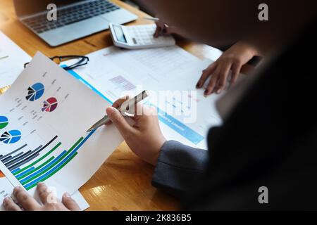 Il dipendente dell'azienda punta al documento per calcolare il budget e verificare la correttezza dell'investimento. Foto Stock