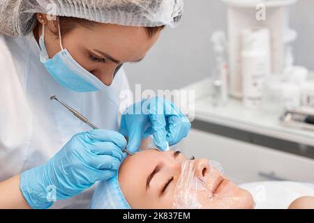 donna durante una procedura meccanica di pulizia del viso Foto Stock