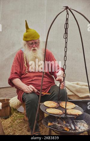 Hojbjerg, Danimarca, agosto 2022: Frittelle di frittelle di un vecchio uomo sul fuoco Foto Stock