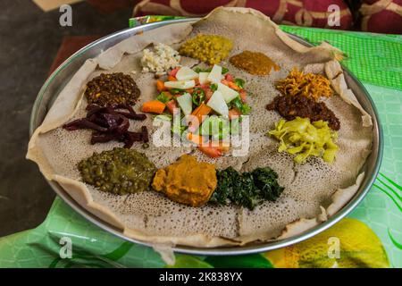 Pasto tipico in Etiopia - Beyainatu. Mearing un po' di tutto. Mix di verdure e stufati su injera flatbread. Foto Stock