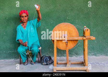 WOLLEKA, ETIOPIA - 14 MARZO 2019: Filo di filatura della donna locale usando il mandrino nel laboratorio delle donne di Ploughshare nel villaggio di Wolleka, Etiopia. Foto Stock