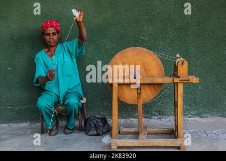 WOLLEKA, ETIOPIA - 14 MARZO 2019: Filo di filatura della donna locale usando il mandrino nel laboratorio delle donne di Ploughshare nel villaggio di Wolleka, Etiopia. Foto Stock