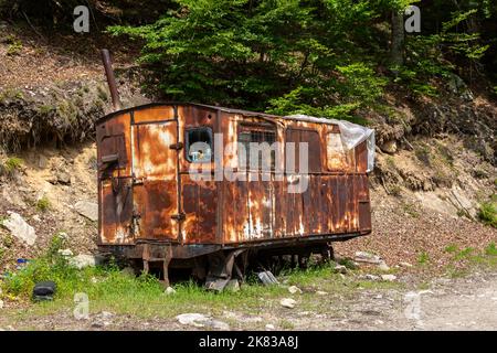 Novaci, Contea di Gorj, Romania – 24 luglio 2022: Carro vecchio e arrugginito nella Valle di Gilort, Novaci, Romania. Serve come riparo per i lavoratori forestali. Foto Stock