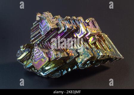 Bismuto bi primo piano su superficie nera.interessante colore e forma cristallo. Cristallo metallico Foto Stock