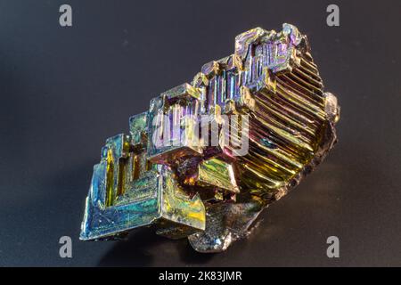 Bismuto bi primo piano su superficie nera.interessante colore e forma cristallo. Cristallo metallico Foto Stock