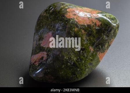 Macro tumbled Unakite Jasper isolato su sfondo grigio Foto Stock