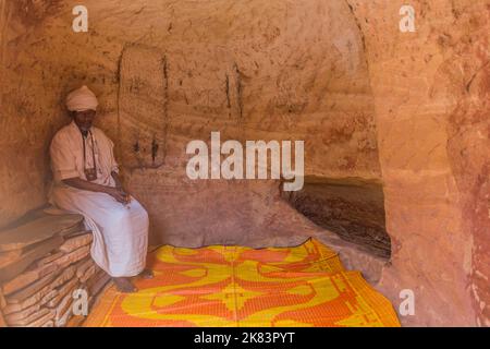 TIGRAY, ETIOPIA - 22 MARZO 2019: Sacerdote nella chiesa scavata nella roccia di Abuna Yemata Guh, regione di Tigray, Etiopia Foto Stock