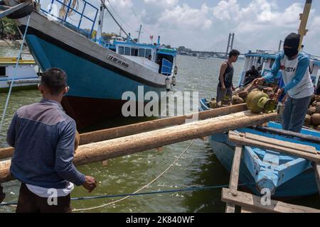 20 ottobre 2022, Kendari, Indonesia: Lavoratori che scaricano le bombole di GPL vuote da 3 kg da sostituire con bombole ricaricate da distribuire via nave da Kendari alle Isole Konawe. PT Pertamina Patra Niaga Sulawesi ha osservato che nel periodo gennaio-settembre 2022, la fornitura di tre chilogrammi di GPL alla Regency delle Isole Konawe nel Sulawesi sudorientale ha raggiunto le 954,24 tonnellate metriche. (Credit Image: © Andry Denisah/SOPA Images via ZUMA Press Wire) Foto Stock