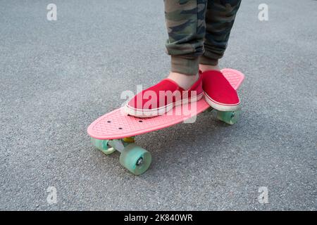 Primo piano su skateboard e gambe. Pattinaggio su una tavola, stile di vita sano Foto Stock