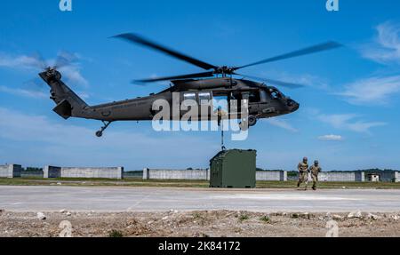 Senior Airmen Giancarlo Hernandez e John Millan-Irizarry, 51st manutenzione Squadron Aerospace Ground Equipment journeymen, corrono dopo aver assicurato un'unità interna Slingable Unit ad un elicottero Black Hawk dell'esercito degli Stati Uniti durante un addestramento integrato a carico di imbracatura presso Osan Air base, Repubblica di Corea, 13 ottobre 2022. I militari del 51st Aircraft Maintenance Group hanno ricevuto il loro primo addestramento pratico sul carico di imbracatura come parte del piano Agile Combat Employment di USAF per produrre Airmen multi-capaci che eseguono regolarmente compiti al di fuori della loro specialità abituale per essere più ben arrotondati. (STATI UNITI Air Force foto di St Foto Stock