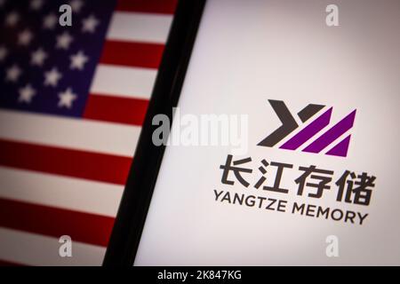 Logo Yangtze Memory Technologies Corp su iPhone sulla bandiera degli Stati Uniti di umore oscuro. YMTC è un produttore cinese di dispositivi integrati semiconduttori Foto Stock