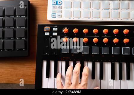 La mano del musicista sulla tastiera midi. Attrezzature musicali moderne per studi di registrazione professionali e studi di musica per la casa. Compositore, musicista, cantante. Chiusura-u Foto Stock