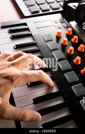 Scatto macro. La mano del musicista sulla tastiera midi. Nuove tecnologie moderne, attrezzature professionali per uno studio musicale, studio di registrazione. Concerto, notte clu Foto Stock