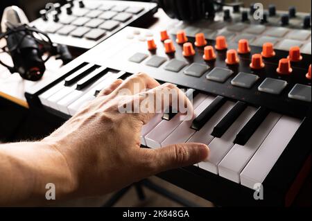 Studio di registrazione. Attrezzatura professionale da studio. La mano del musicista sulla tastiera midi. Primo piano. Lavorare con suono, podcast, registrazione di opere musicali, arr Foto Stock