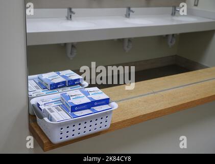 Prodotti per l'igiene femminile distribuiti gratuitamente nel bagno di una scuola Foto Stock