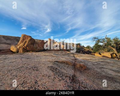 Bagliore di granito rosa dell'Enchanted Rock state Natural Area vicino a Fredericksburg, Texas, con formazioni rocciose al centro. Foto Stock