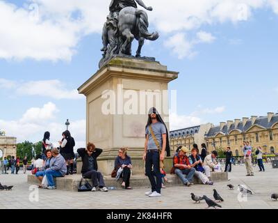 Parigi Francia - Giugno 19 2009; turisti che si rilassano intorno alla base della statua equestre di Re Luigi XIV al Museo del Louvre Foto Stock