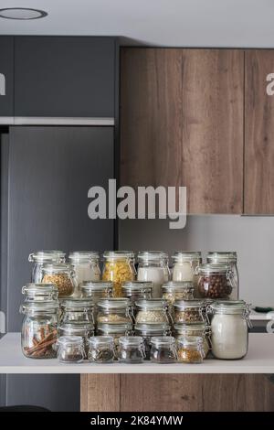 Varietà di cibi secchi, cereali, noci, cereali in vasetti di vetro. Foto Stock